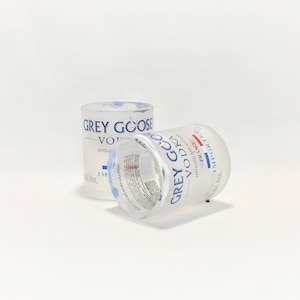 K&ouml;nnte beinhalten: Zwei klare Glas-Shotgl&auml;ser mit der Aufschrift "Grey Goose Vodka". Die Gl&auml;ser sind teilweise mit einer klaren Fl&uuml;ssigkeit gef&uuml;llt.
