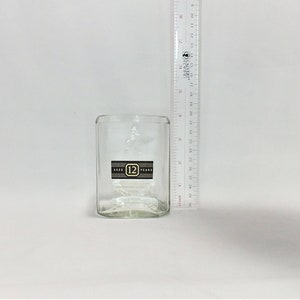 May include: A clear glass tumbler with a label that reads "Aged 12 Years".