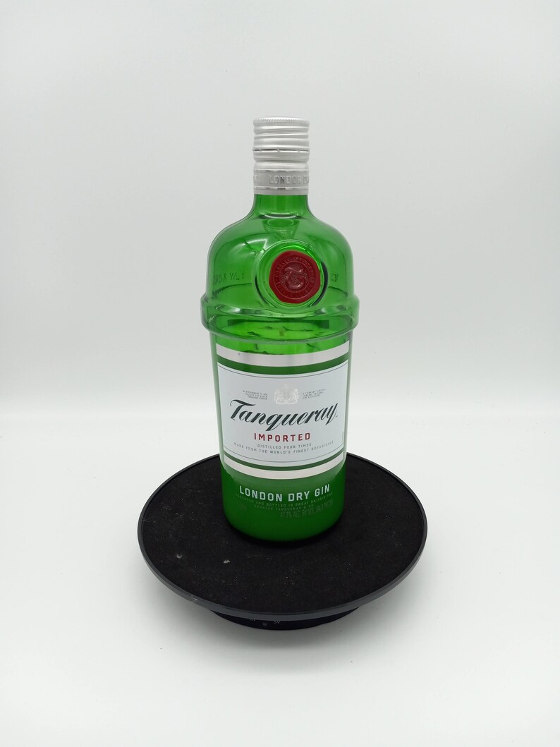 K&ouml;nnte beinhalten: Eine gr&uuml;ne Glasflasche Tanqueray London Dry Gin. Die Flasche hat einen silbernen Verschluss und ein rotes Etikett mit dem Markennamen und den Worten "Importiert" und "London Dry Gin".