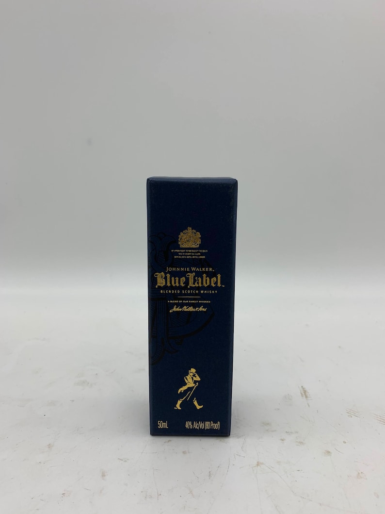 May include: A blue box with gold lettering for Johnnie Walker Blue Label Blended Scotch Whisky. The box features the Johnnie Walker logo and the text "50ml 40% Alc/Vol (80 Proof)".
