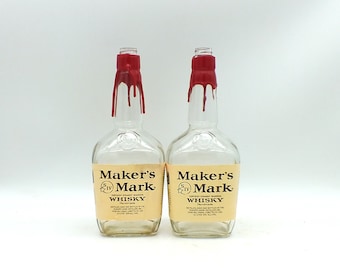 May include: Two empty glass bottles with red wax seals. The bottles are labeled "Maker's Mark Kentucky Straight Bourbon Whiskey Handmade".