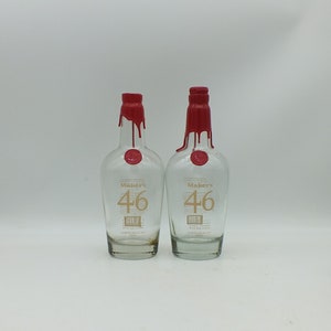 May include: Two clear glass bottles with red wax seals. The bottles are labeled "Maker's 46".