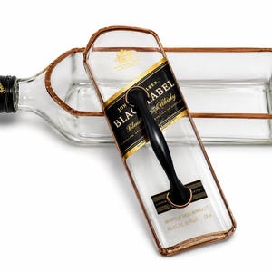 Puede incluir: Una bandeja de servicio hecha de una botella de whisky escoc&eacute;s Johnnie Walker Black Label. La botella de vidrio transparente tiene un asa negra y una etiqueta con borde dorado. Un art&iacute;culo reciclado &uacute;nico.