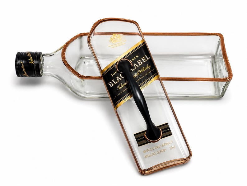 Puede incluir: Una bandeja de servicio hecha de una botella de whisky escoc&eacute;s Johnnie Walker Black Label. La botella de vidrio transparente tiene un asa negra y una etiqueta con borde dorado. Un art&iacute;culo reciclado &uacute;nico.