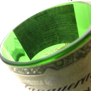 May include: An empty green glass bottle with a white label that reads "Tanqueray" and features a barcode. The label is partially visible.