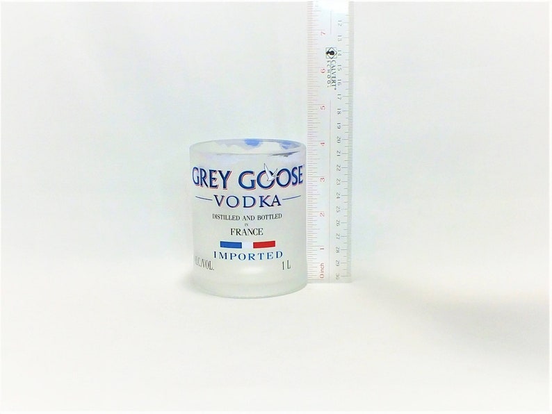 K&ouml;nnte beinhalten: Eine gefrostete Glasflasche Grey Goose Wodka. Die Flasche ist 1 Liter gro&szlig; und tr&auml;gt die Aufschrift "Destilliert und abgef&uuml;llt in Frankreich" und "Importiert".