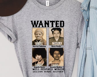May include: A gray t-shirt with the word "WANTED" above four sepia-toned portraits of historical figures. The shirt includes the text "WELL-BEHAVED WOMEN SELDOM MAKE HISTORY."
