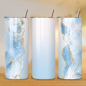 Puede incluir: Tres vasos de acero inoxidable con un diseño de mármol azul y dorado. Los vasos tienen un efecto degradado, que se desvanece del blanco al azul claro.