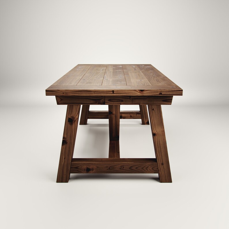 May include: A rustic wooden table with a rectangular top and a simple, sturdy design. The table has a dark brown finish and is made of solid wood.