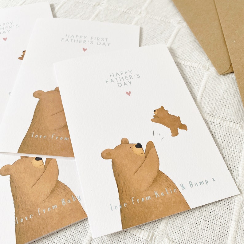 May include: A set of four cards with a brown bear illustration. The cards say "Happy First Father's Day" and "Happy Father's Day". The cards are personalized with the text "love from Baby" and "love from Katie & Bump x".