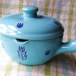 May include: A light blue ceramic serving dish with a lid and a handle. The dish is decorated with blue tulip designs.
