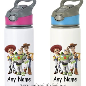 May include: Two white water bottles with a Toy Story theme. The bottles have a pink and blue lid with a grey handle. The bottles feature a graphic of Woody, Buzz Lightyear, and Jessie. The text "Any Name" is printed on the bottles.