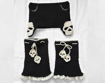 May include: A black crochet set with white skull accents. The set includes a top, leg warmers, and a headband.
