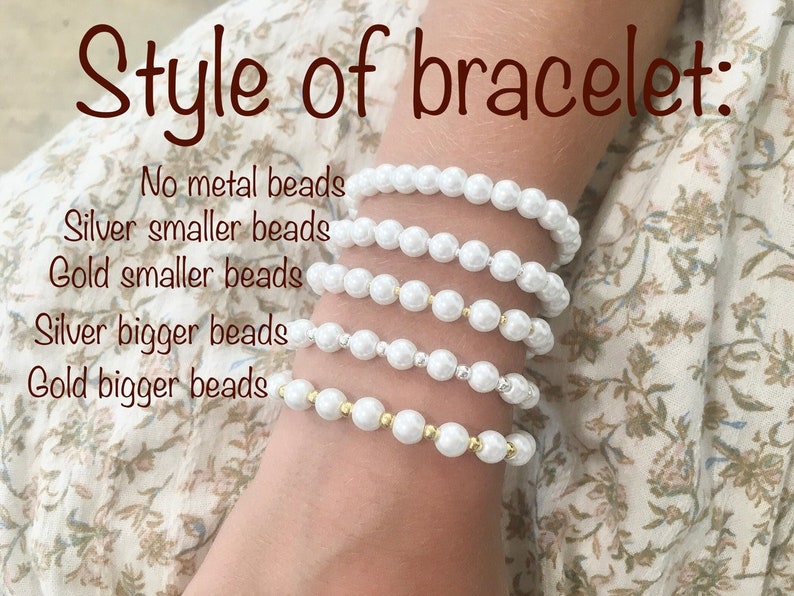 Puede incluir: Cinco pulseras de perlas blancas con diferentes estilos. Las pulseras est&aacute;n apiladas en la mu&ntilde;eca de una persona. La pulsera superior no tiene cuentas met&aacute;licas, la segunda pulsera tiene cuentas plateadas, la tercera pulsera tiene cuentas doradas, la cuarta pulsera tiene cuentas plateadas m&aacute;s grandes y la quinta pulsera tiene cuentas doradas m&aacute;s grandes.