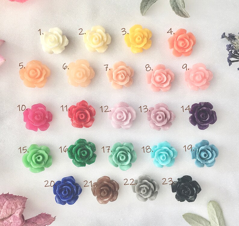 May include: Twenty-three assorted plastic flower embellishments in various colors, including pink, red, green, blue, and purple. The flowers are arranged in rows, numbered 1 through 23.