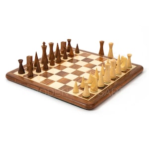 Könnte beinhalten: Ein Schachspiel aus Holz mit hellbraunen und dunkelbraunen Figuren auf einem Holzbrett mit grünem Filzbezug. Die Figuren sind in der Startposition auf dem Brett angeordnet.