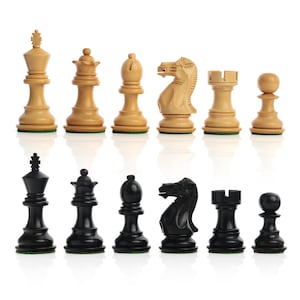May include: A complete chess set with pieces in two contrasting colors: light wood and black. The pieces include a king, queen, bishop, knight, rook, and pawn. The set is displayed on a white surface.