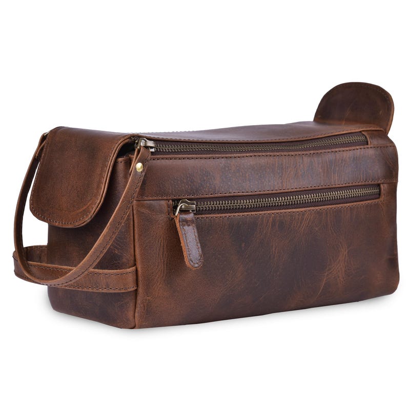 May include: A brown leather toiletry bag with multiple zippered compartments and a flap closure. The bag has a handle and a shoulder strap. The leather has a distressed appearance.