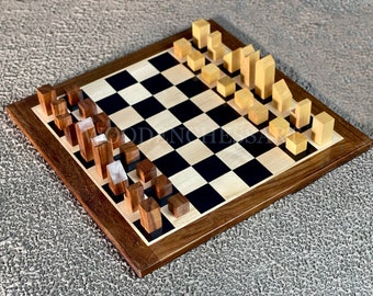May include: A wooden chess set with light and dark brown pieces arranged on a black and white checkered board. The board is made of wood with a dark brown frame.