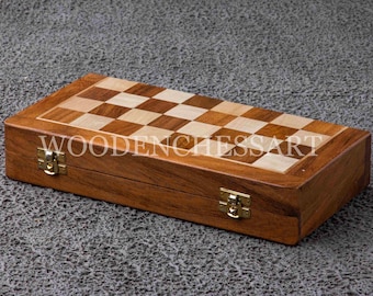 May include: A wooden chessboard set with a brown and light wood checkered design. The board is closed and has two brass clasps. The text "WOODENCHESSART" is printed on the board.