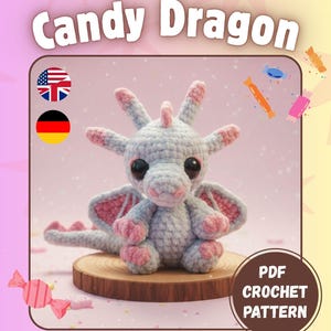 Könnte beinhalten: Ein gehäkelter Drachen in Grau- und Rosatönen, mit großen schwarzen Augen, sitzt auf einer Holzscheibe. Das Bild enthält den Text "Candy Dragon" und "PDF Crochet Pattern". Dekorative Süßigkeiten-Illustrationen sind ebenfalls vorhanden.
