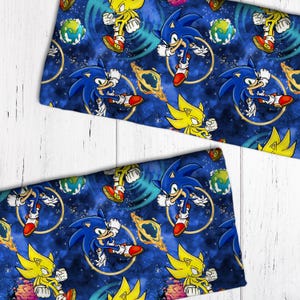 May include: Blue and yellow cartoon characters on a blue background with swirling patterns. The characters are Sonic the Hedgehog and Super Sonic. The background is a galaxy-like pattern with stars and planets.
