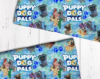 May include: Blue and green fabric with a repeating pattern of cartoon dogs, paw prints, and the text "Puppy Dog Pals".