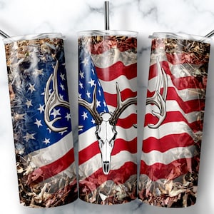 May include: Three stainless steel tumblers with a camouflage pattern and an American flag design. The flag has a deer skull with antlers in the center.