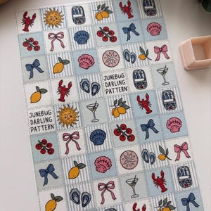 Può includere: Un foglio a motivi con un design ripetuto di illustrazioni a tema estivo. Il design include immagini di aragoste, limoni, fiocchi, conchiglie e cocktail, su uno sfondo a righe blu e bianche. È presente anche il testo "JUNEBUG DARLING PATTERN".