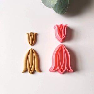 May include: Two sets of tulip-shaped cookie cutters. One set is pink and the other is gold.