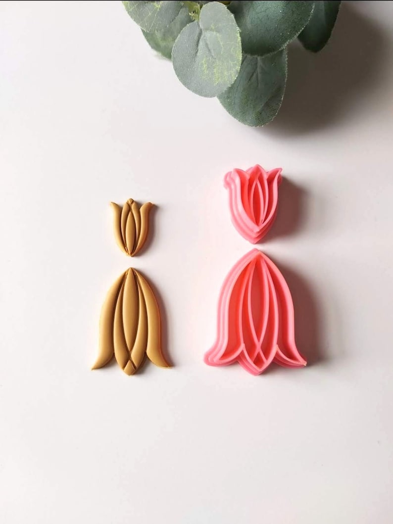 May include: Two sets of tulip-shaped cookie cutters. One set is pink and the other is gold.