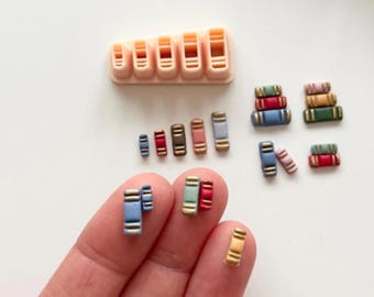 Könnte beinhalten: Eine Sammlung von Miniatur-Buchmodellen in verschiedenen Farben, darunter Blau, Rot und Braun, zusammen mit einem beigefarbenen, buchförmigen Ausstecher. Der Text "Digital STL File" ist unten zu sehen. Diese Artikel sind wahrscheinlich für Bastel- oder Miniaturprojekte gedacht.