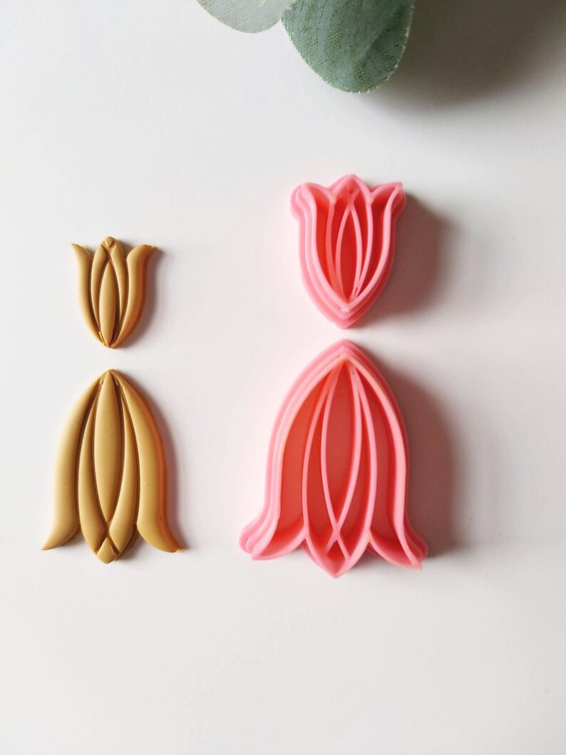 May include: Two sets of tulip-shaped cookie cutters. One set is pink and the other is gold.