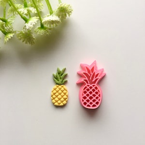 Könnte beinhalten: Zwei Ausstecher in Form von Ananas, einer rosa und einer gelb. Der rosa Ausstecher ist größer als der gelbe Ausstecher.