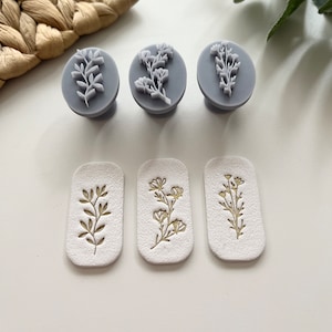 May include: Three gray round stamps with white floral designs and three white rectangular stamps with gold floral designs.