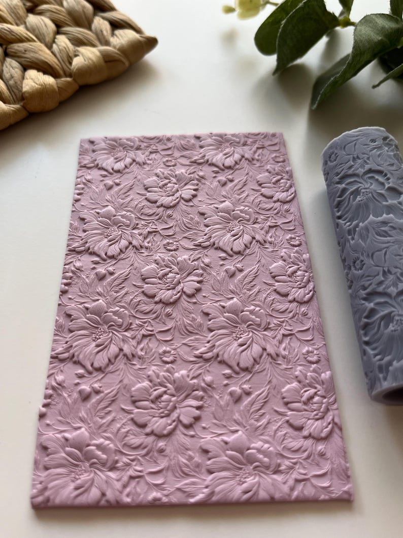 May include: A pink silicone rolling pin with a floral pattern. The rolling pin is used for decorating cakes and pastries.