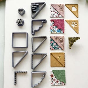 May include: A collection of craft items, including grey plastic corner-shaped cookie cutters, heart and paw print shapes, and decorative leather squares with floral patterns and the text "reading fuels the soul."