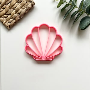 May include: Pink plastic seashell cookie cutter.