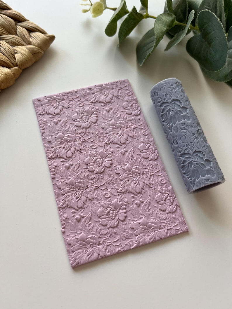May include: A set of two pink silicone rolling pins with a floral pattern. The rolling pins are used for decorating fondant, clay, or other crafts.