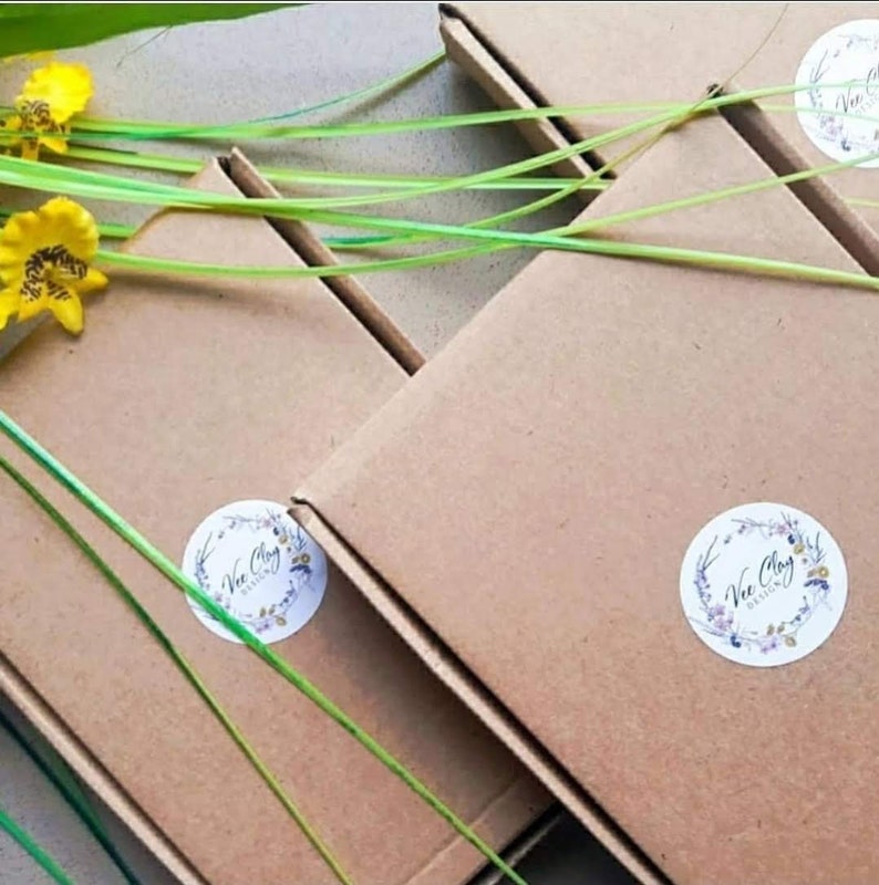 May include: Four brown cardboard boxes with a white circular logo that says "Vee Clay Designs" on each box. The boxes are stacked on top of each other.