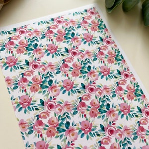 Könnte beinhalten: Ein nahtloses Muster mit rosa Aquarellrosen und grünen Blättern auf weißem Hintergrund.