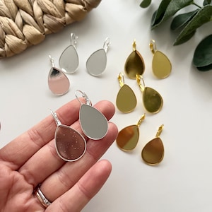 Puede incluir: Surtido de bases para pendientes en forma de lágrima en plata, oro y oro rosa. Las bases están listas para ser personalizadas con resina, pintura u otros adornos.