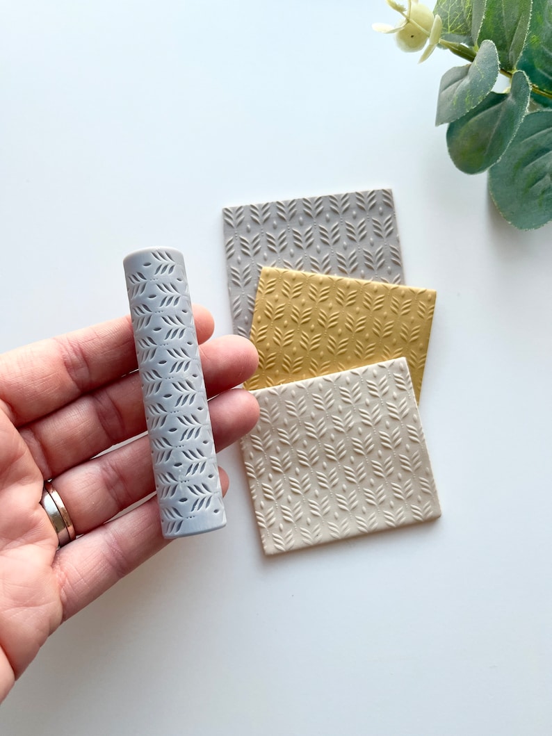 May include: A gray textured roller with a leaf pattern, and three square textured sheets of polymer clay in gray, beige, and yellow with the same leaf pattern.