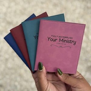 Puede incluir: Un conjunto de cuatro fundas rectangulares de piel sintética en azul, granate, verde azulado y malva. Cada funda presenta el texto impreso en negro "FULLY ACCOMPLISH Your Ministry" y "2 TIMOTHY 4:5" con una línea decorativa bajo la referencia.