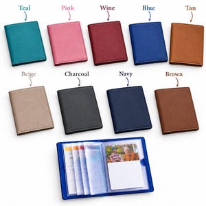 May include: A collection of nine rectangular card holders in various colors including teal, pink, wine, blue, tan, beige, charcoal, navy, and brown. One blue card holder is open, displaying multiple clear plastic sleeves for cards.