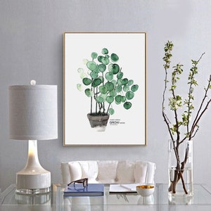 以下が含まれることがあります： 白い背景に、鉢植えの緑色の植物を描いた水彩画。植物のそばには「Where a Green Grow Where Your Heart Is」という文字が書かれている。