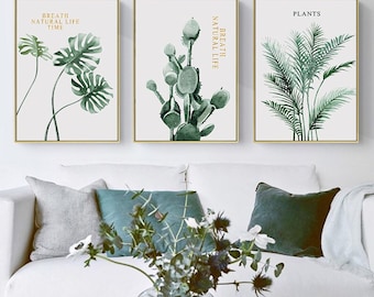 May include: Three framed watercolor paintings of green plants. The leftmost painting features a monstera plant with the text "Breath Natural Life Time". The middle painting features a cactus with the text "Breath Natural Life". The rightmost painting features a palm tree with the text "Plants".