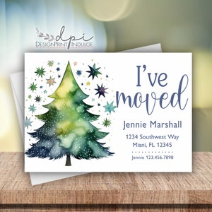 May include: A watercolor illustration of a green Christmas tree with blue and gold stars. The text "I've moved" is written in blue cursive font. Below the text is the name "Jennie Marshall" and a new address.