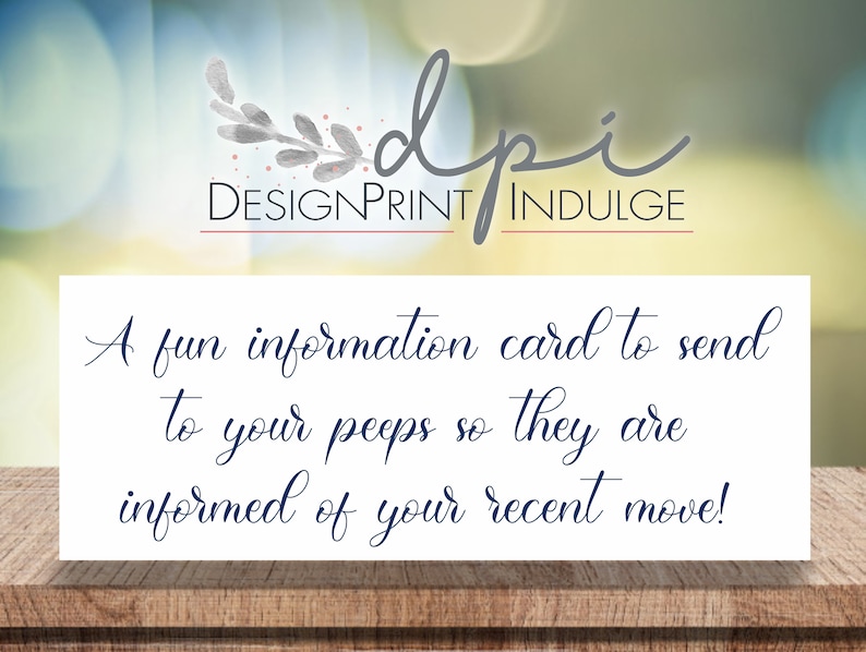 May include: A white card with blue text that reads "A fun information card to send to your peeps so they are informed of your recent move!" The card is on a wooden surface with a blurred background.