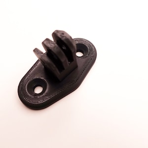 May include: Black plastic GoPro mount with three prongs and two screw holes.